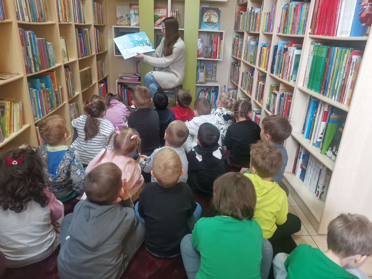 Przedszkolaki słuchające czytanej książki Bądź dzielny pingwinku