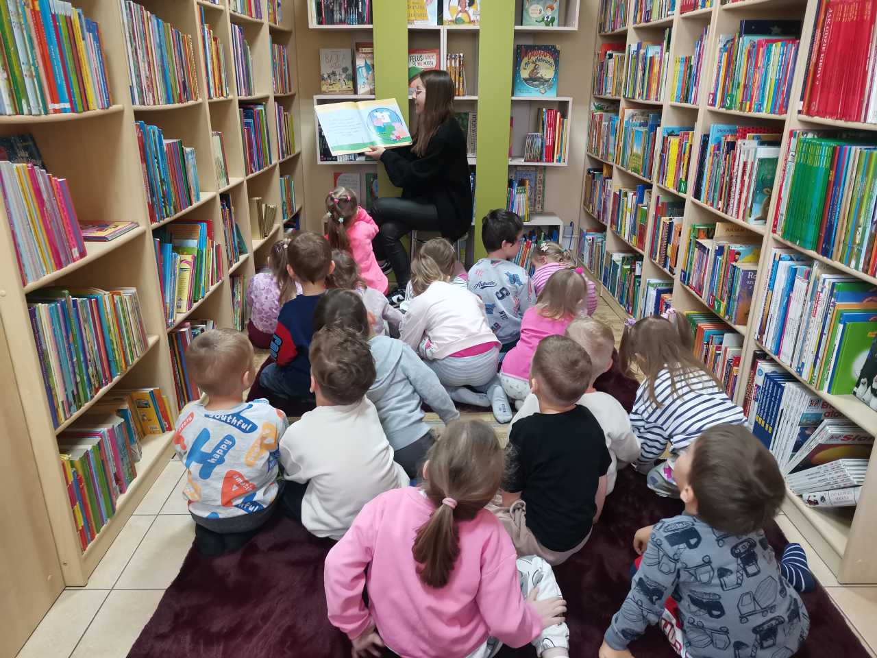 Przedszkolaki słuchające czytanego opowiadania Wielkie pranie z książki W co się bawi Świnka Peppa